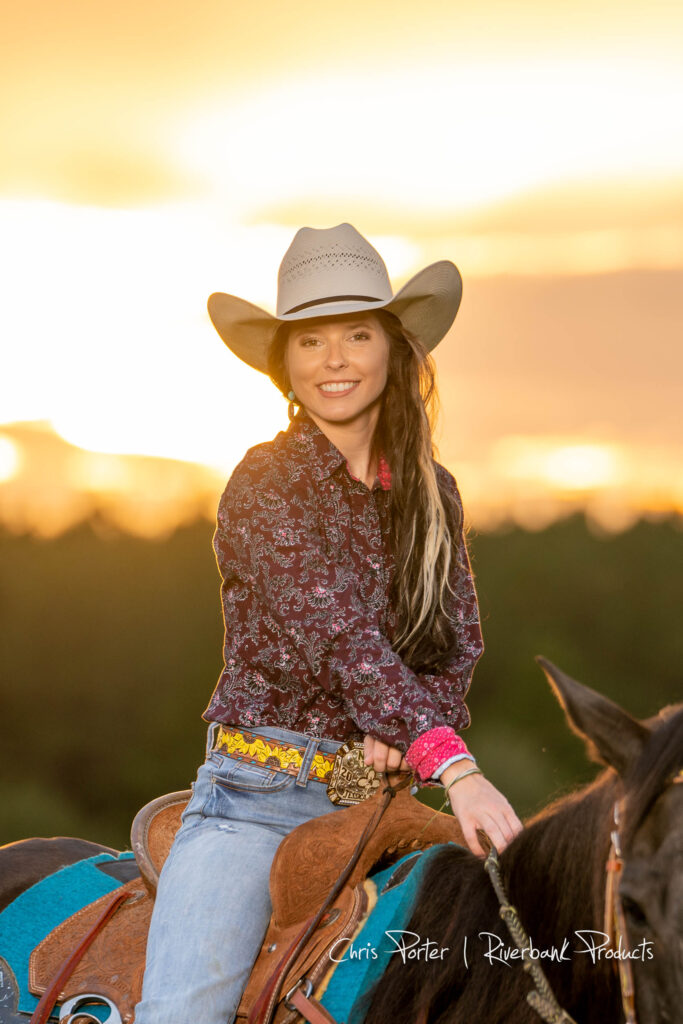 Young cowgirl on horseback at sunset